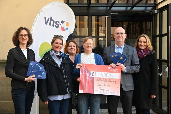 6 Personen halten den Spendenscheck und Gutscheine für die KulturTafel in den Händen.