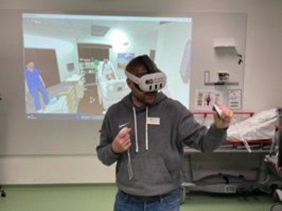 Das Skills Lab der Bamberger Akademien Ein Mann hat eine VR-Brille auf und "übt" Pflegehandgriffe